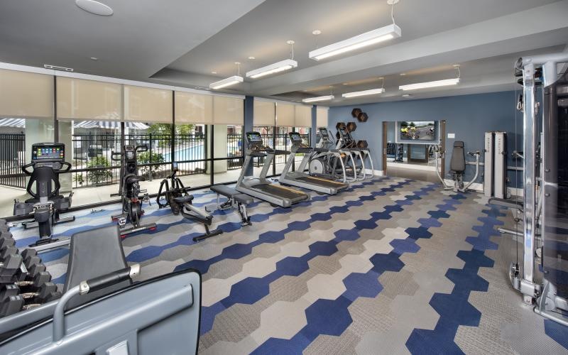 Large fitness center with ample machines and wood floors