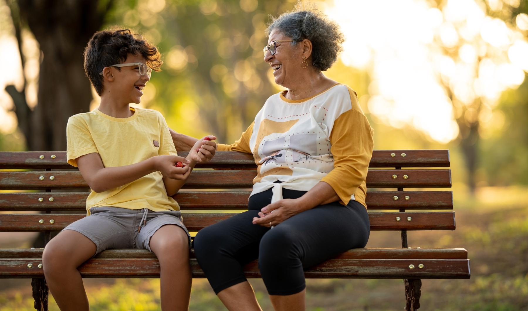 a woman and her grandson sitting on a park bench