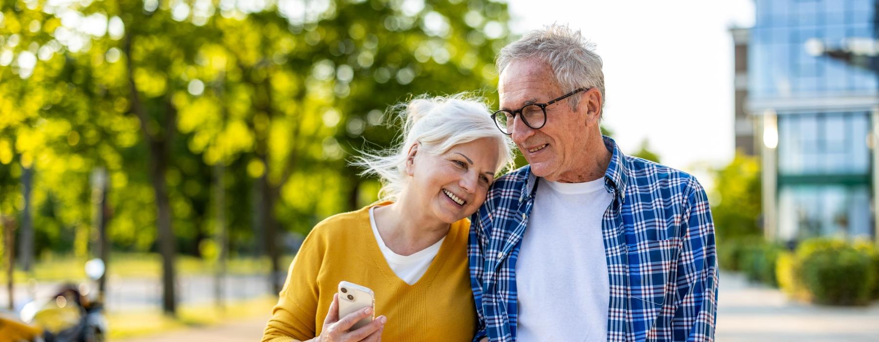 a man and woman smiling and walking down a street