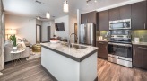 Spacious and well lit kitchen with stainless steel appliances and dark accents 