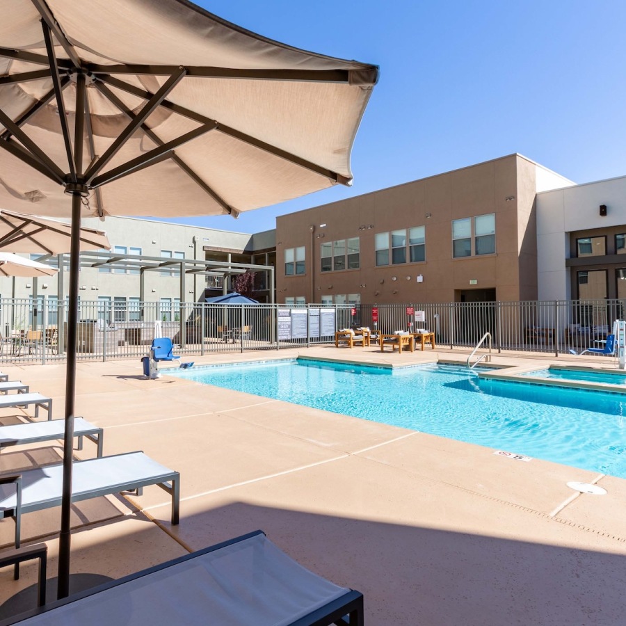 Relax and unwind poolside swimming pool in a courtyard with lounge chairs and umbrellas