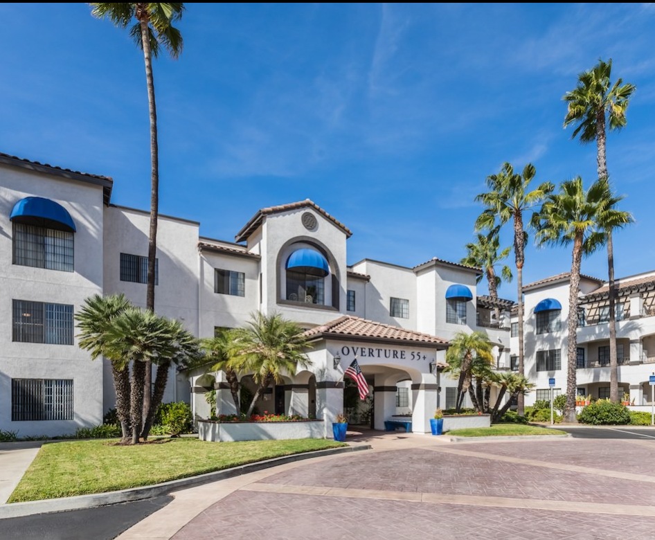 a building with palm trees around it and the sky in the background