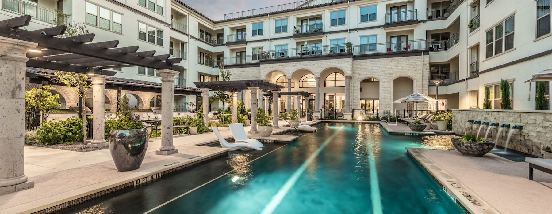 swimming pool in a courtyard with lounge chairs