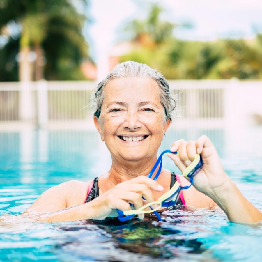 Swimming Pool A resident smiling and swimming in the outdoor swimming pool at Overture Dr. Phillips apartments in Orlando, FL.