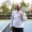 a smiling man holding a tennis racket on the court