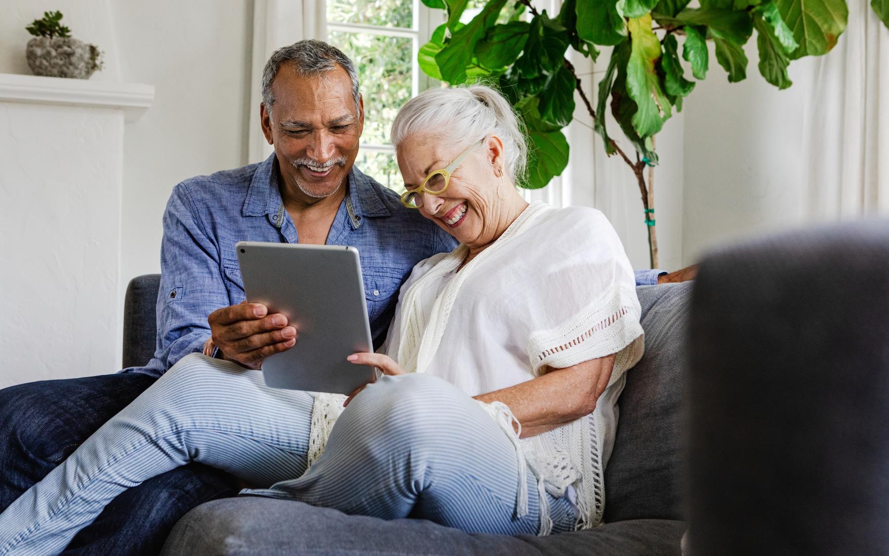 Lifestyle Couple looking at an Ipad and smiling