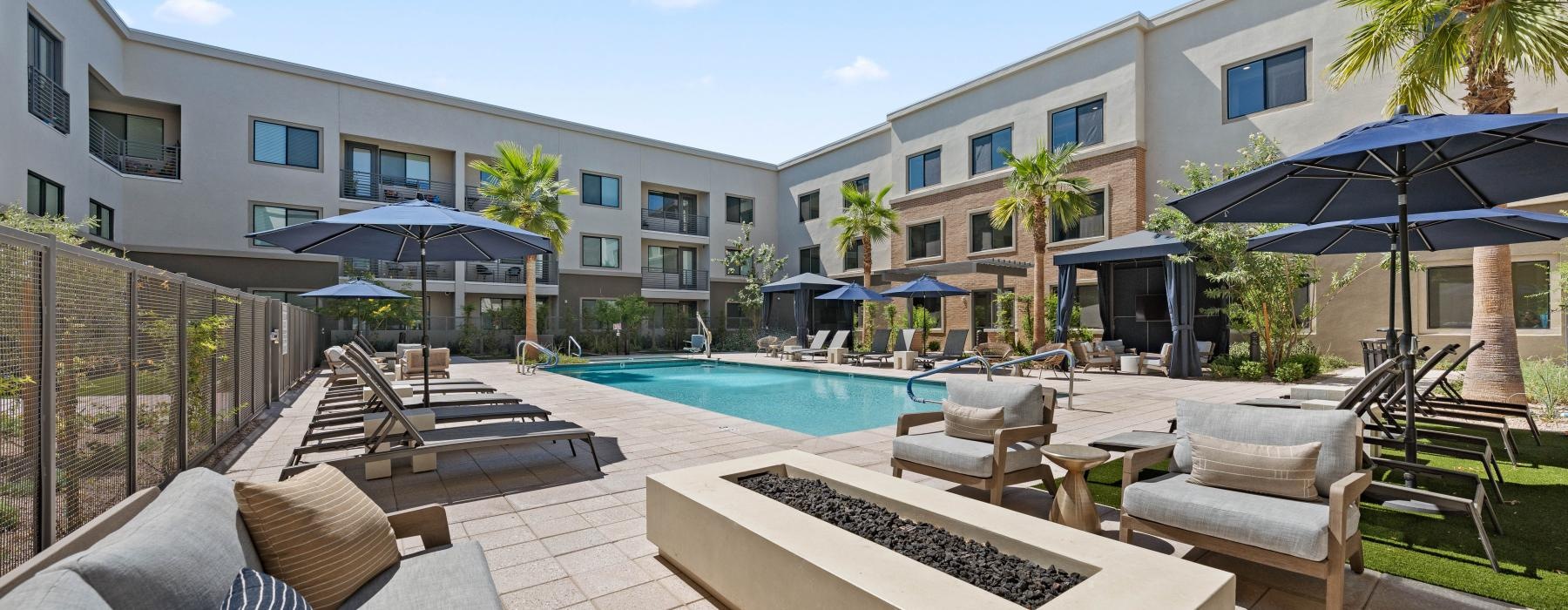 a pool and lounge chairs in a courtyard of a house