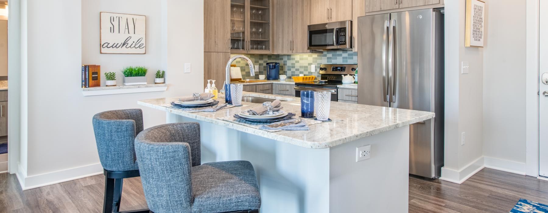 Spacious well lit kitchen with wood floors and stainless steel appliances