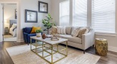 Spacious and well lit living room with wood floors and a large window