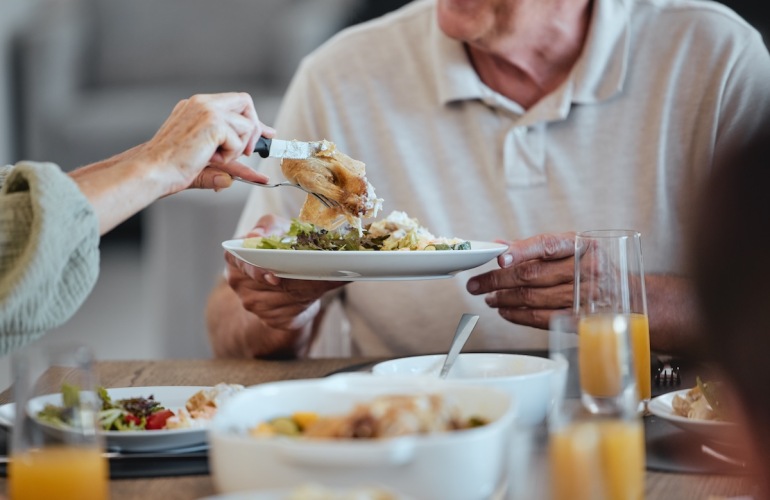 a man holding a plate and receiving thanksgiving food