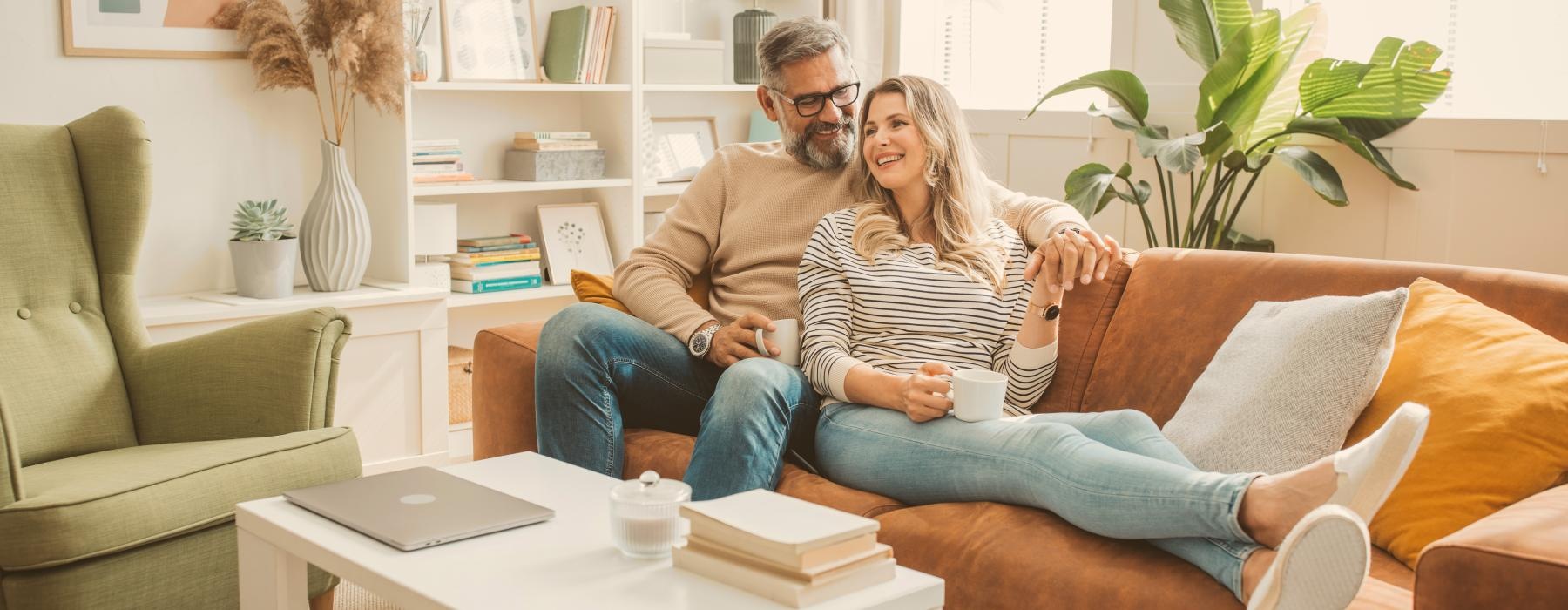 Couple sitting on a couch laughing 