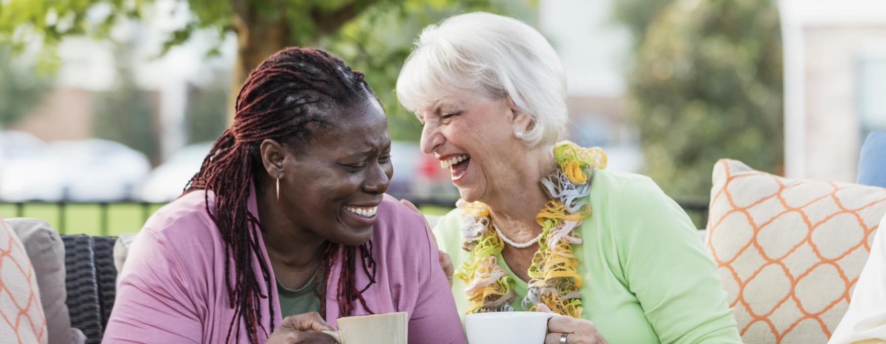 a couple of women sitting on a couch and laughing