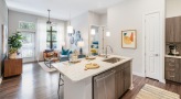 Spacious and well lit kitchen with stainless steel appliances and dark accents 