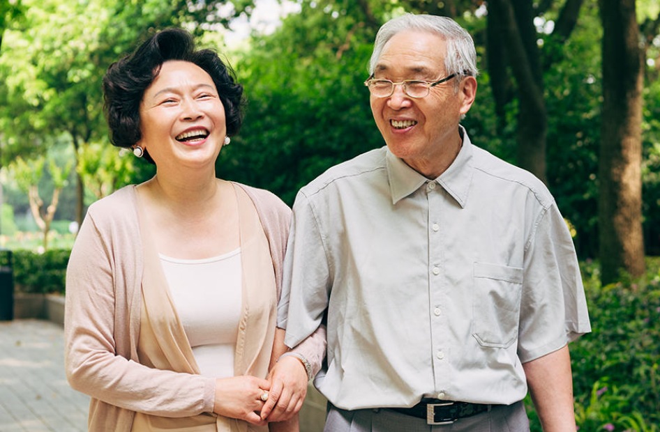 Close to Everything Couple walking in a park smiling and holding hands