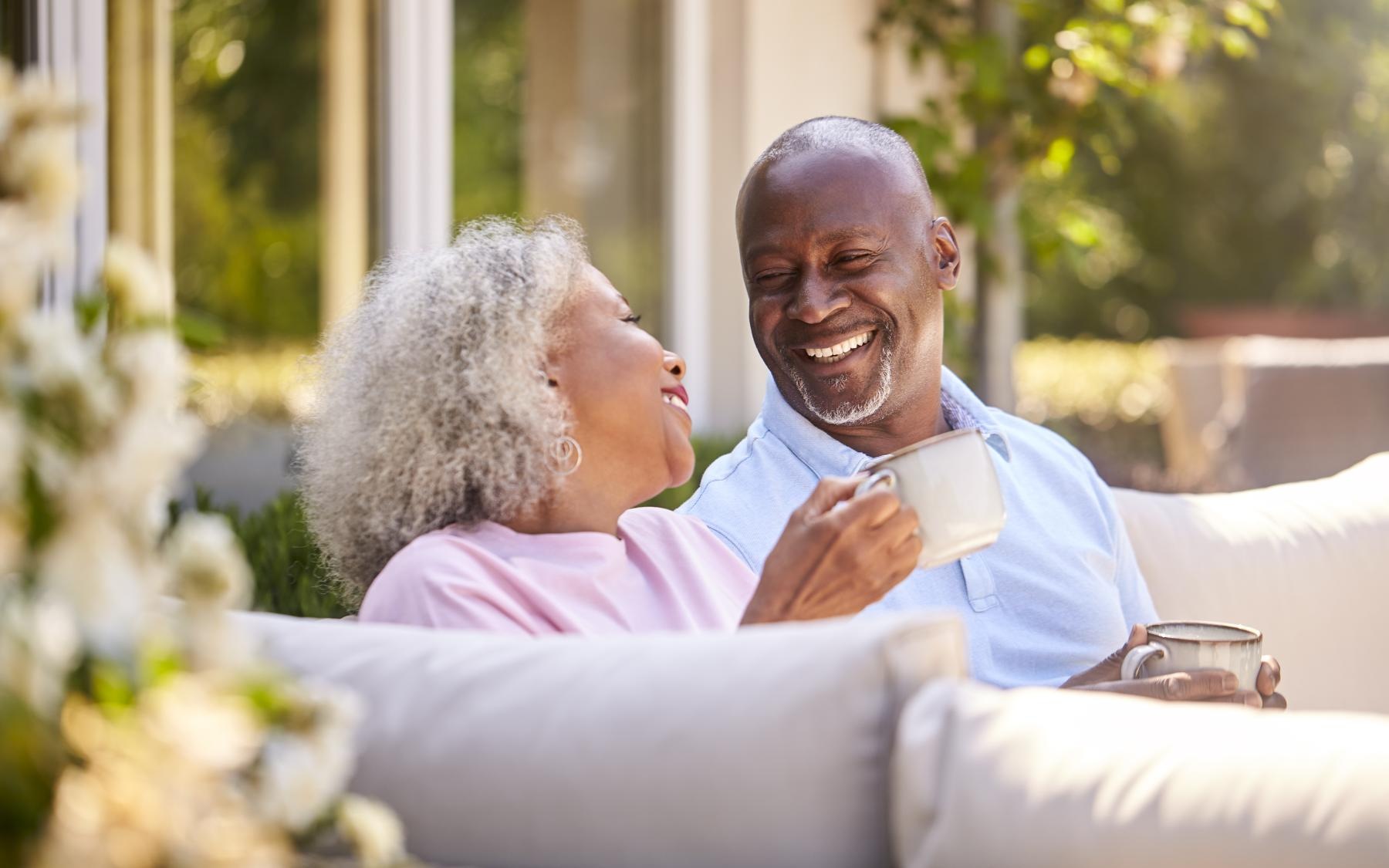 Lifestyle Couple sitting on patio smiling