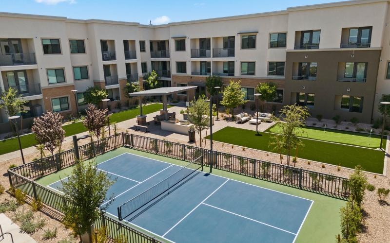 a courtyard with trees and a building in the background