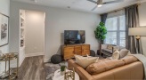 Spacious and well lit living room with wood floors and a large window