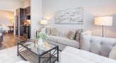 Spacious and well lit living room with wood floors and a large window