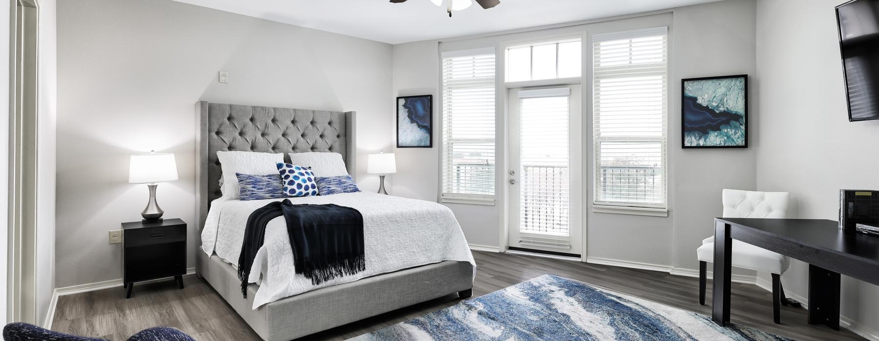 Well lit bedroom with carpeted flooring and private balcony