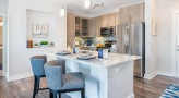 Spacious and well lit kitchen with stainless steel appliances and dark accents 