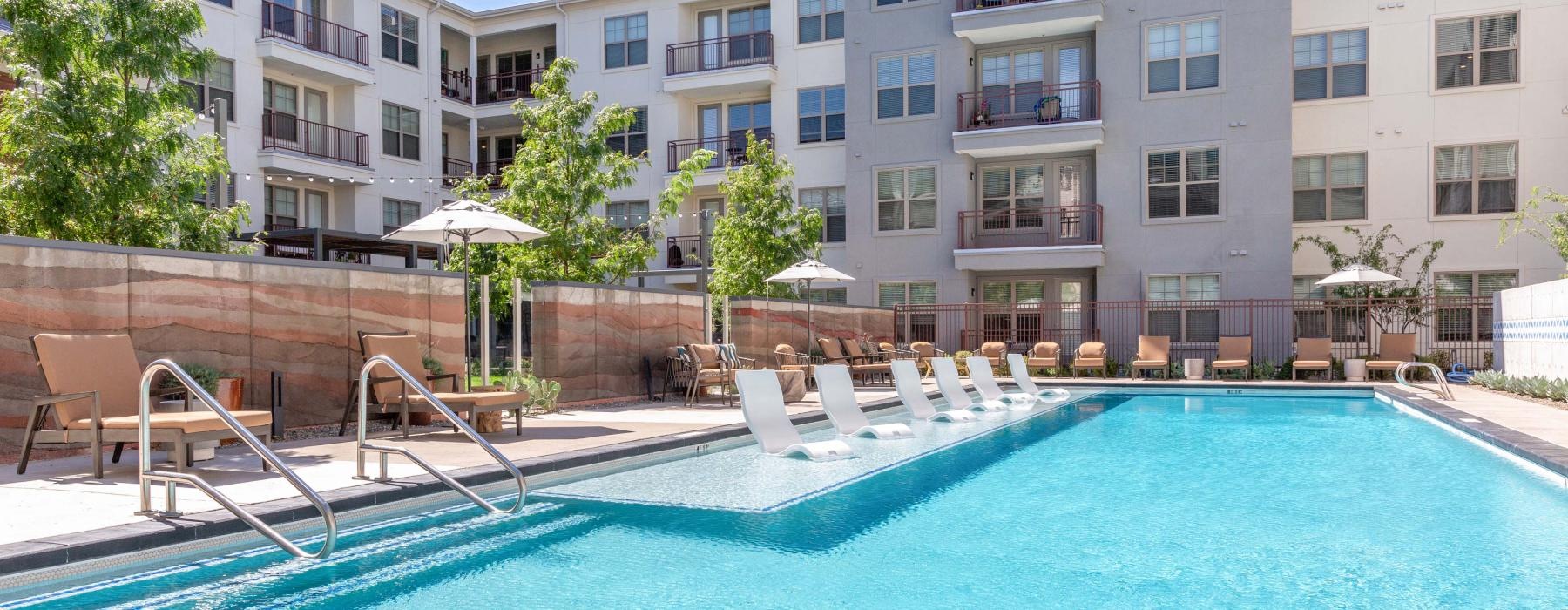 Large sparkling pool with large pool deck and lounge chairs