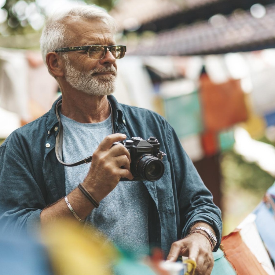 Lifestyle Man walking outside with a camera