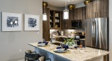 Spacious and well lit kitchen with stainless steel appliances and dark accents 