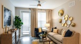 Spacious and well lit living room with wood floors and a large window