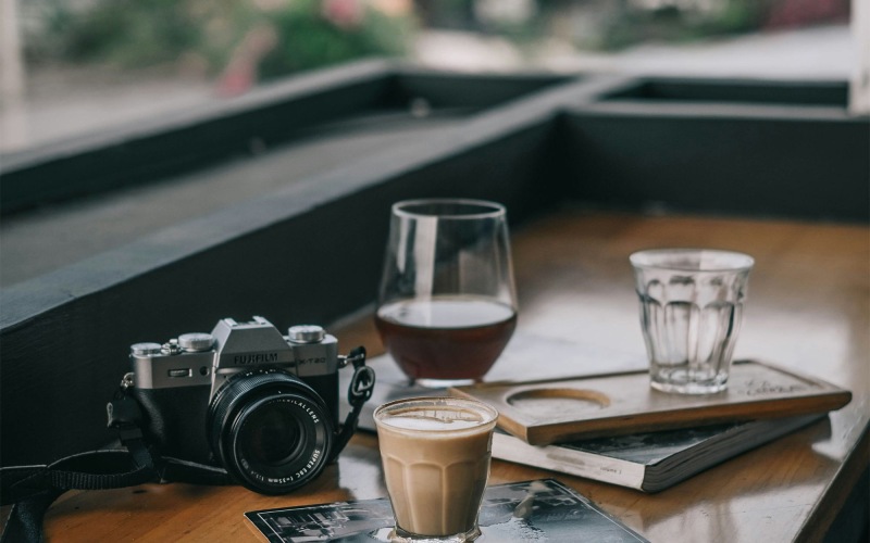 a camera and cup of coffee on a table