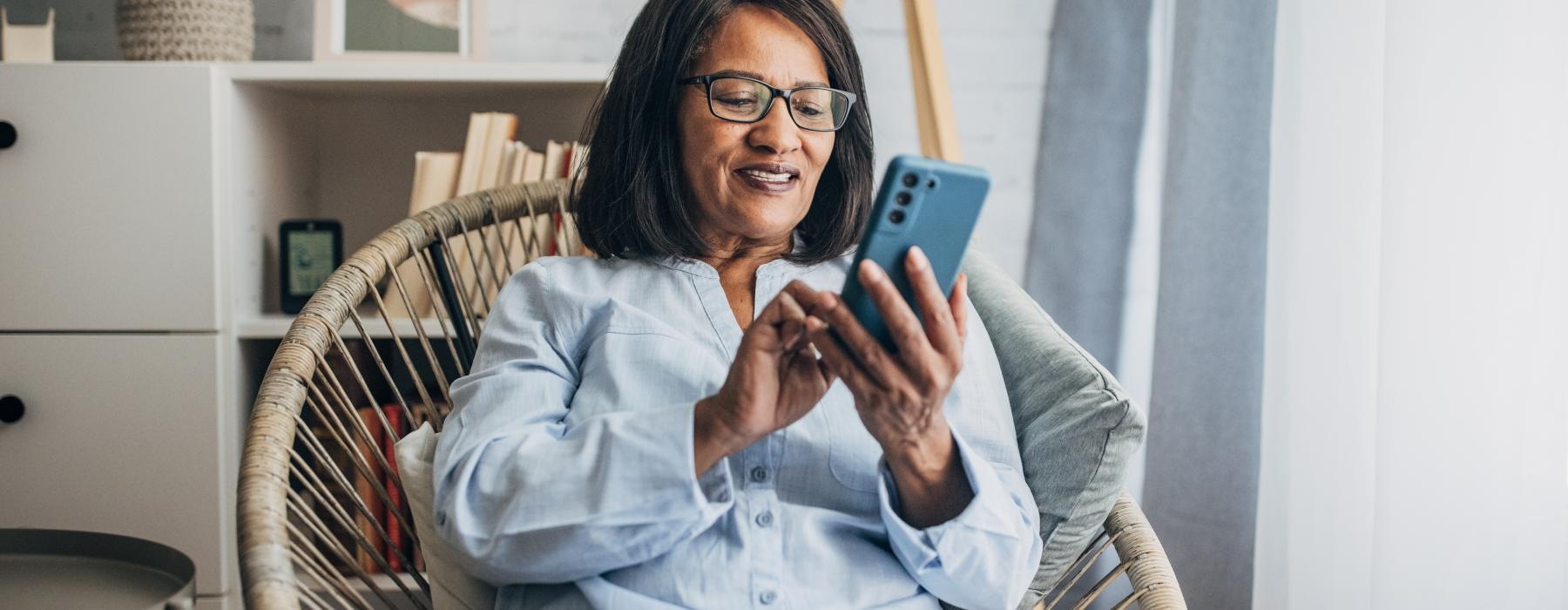 woman sitting in her living room on her phone