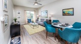 Spacious and well lit living room with wood floors and a large window