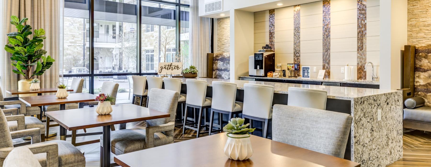 Large lounge area with bar seating and floor to ceiling windows