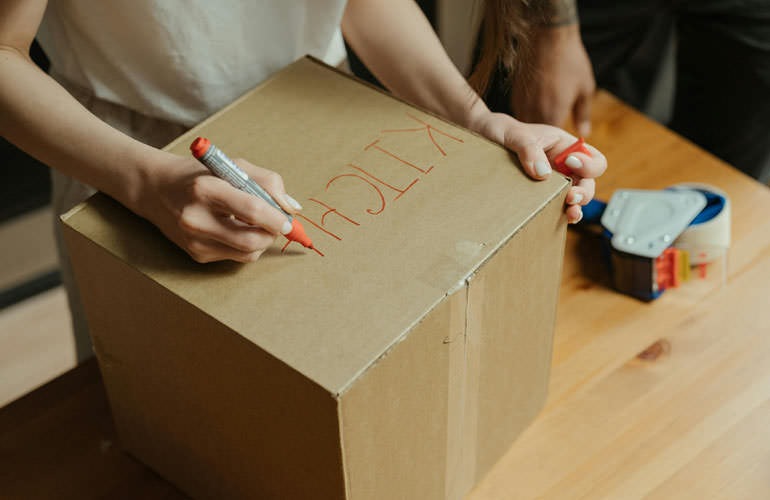 woman writing on a box