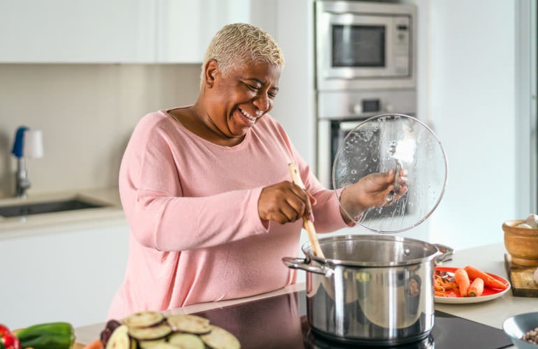 woman happily cooking in her kitchen