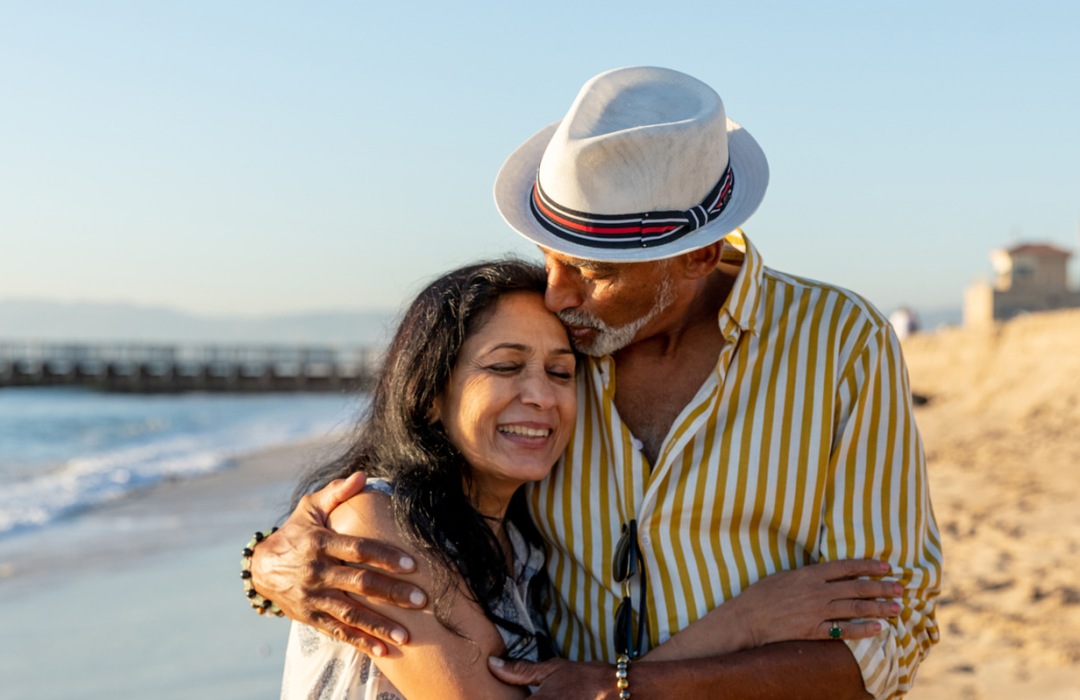 Senior couple embracing while standing on a beach in California