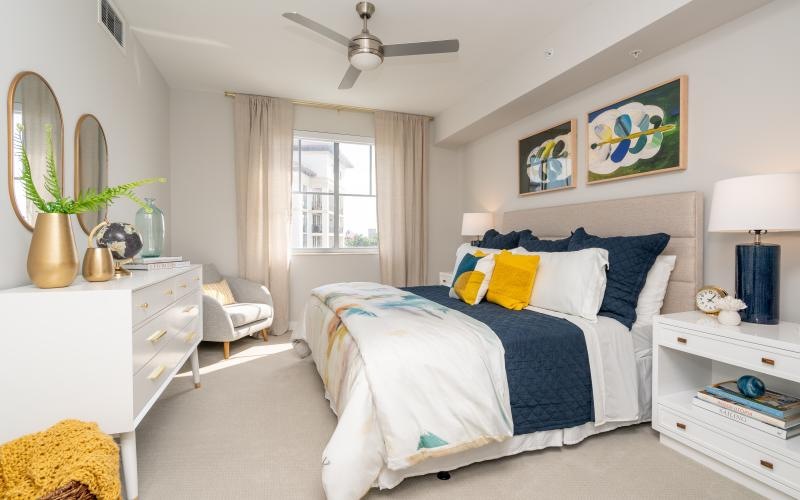 Large well lit bedroom with carpets and large windows 