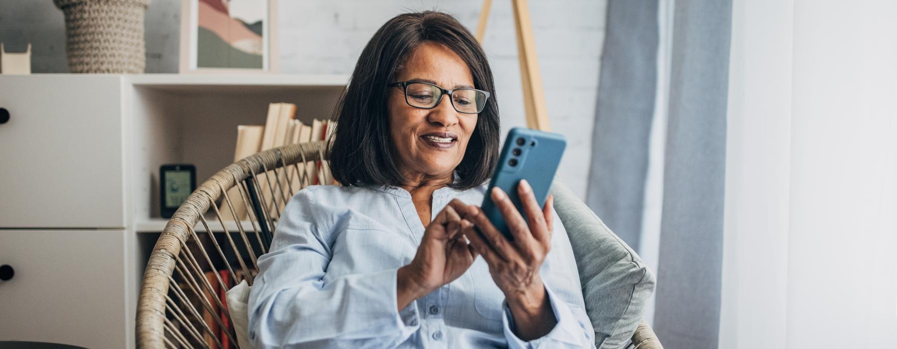 a woman sitting in a chair looking at her phone