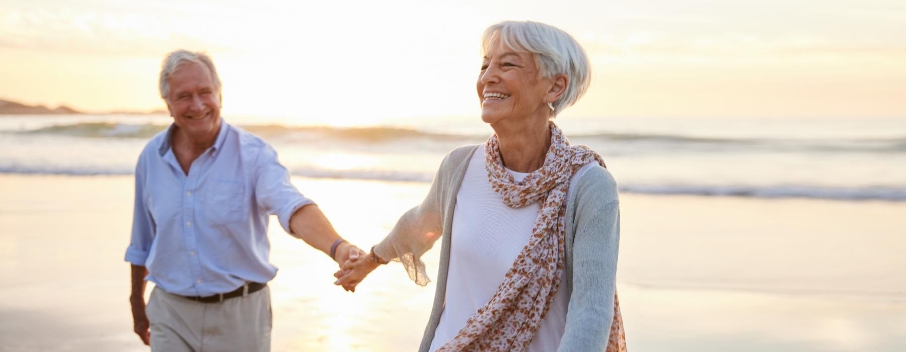 a man and woman holding hands on a beach