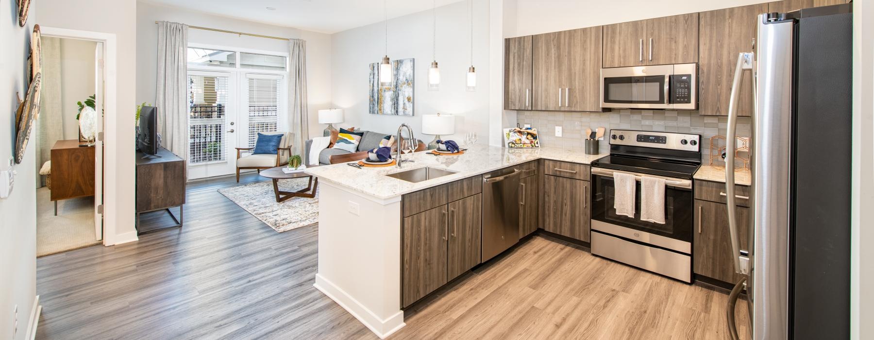 Spacious well lit kitchen with wood floors and stainless steel appliances