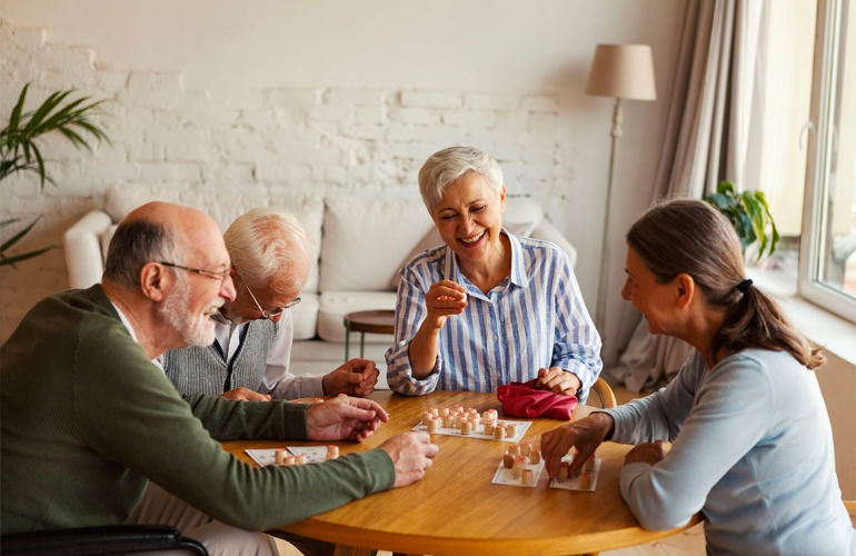 Group of senior adults playing card games at a table.