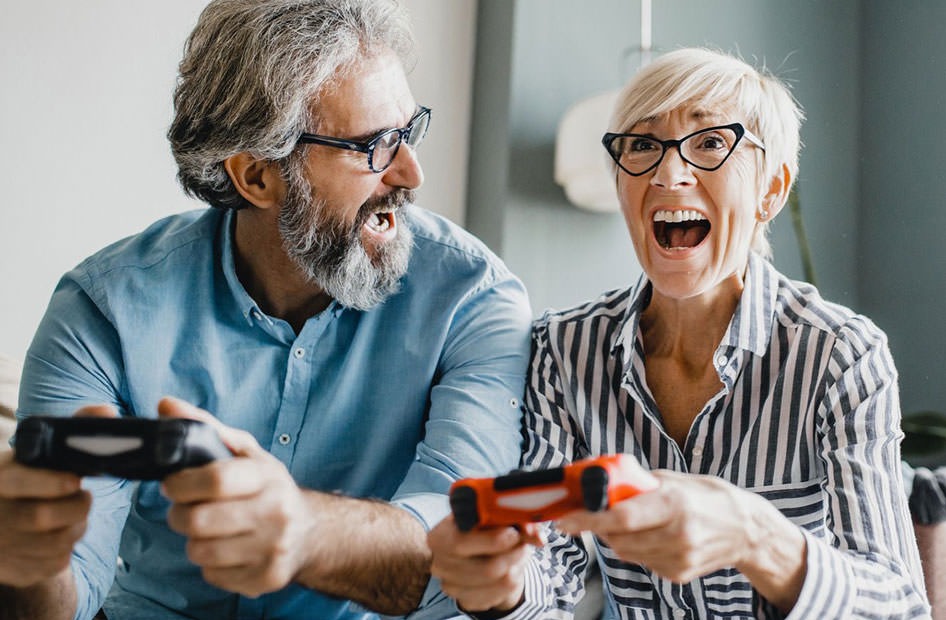 Discover What Life is Like at Overture man and woman on couch with controllers in their hands playing video games