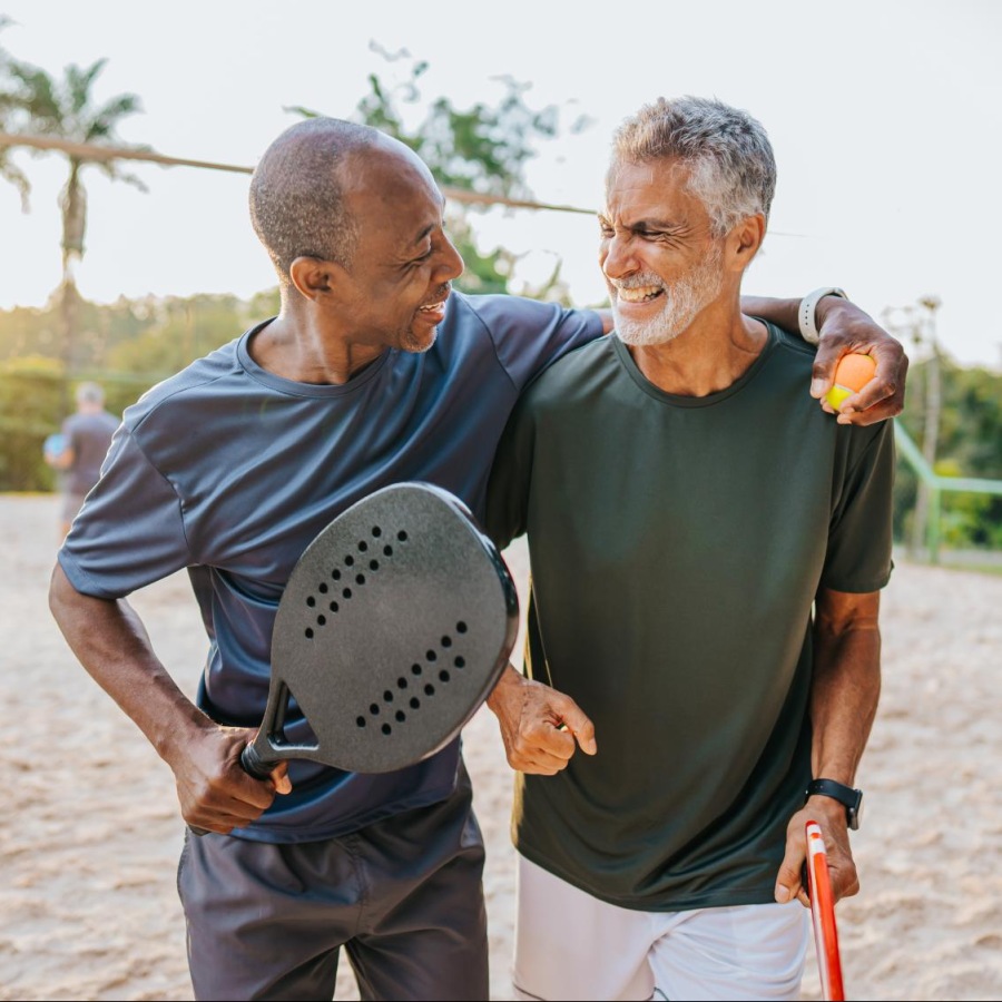 Love where you live two men playing a game at the beach smiling