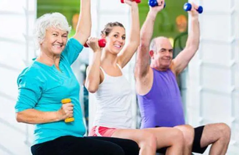 Senior adults exercising together by lifting hand weights.