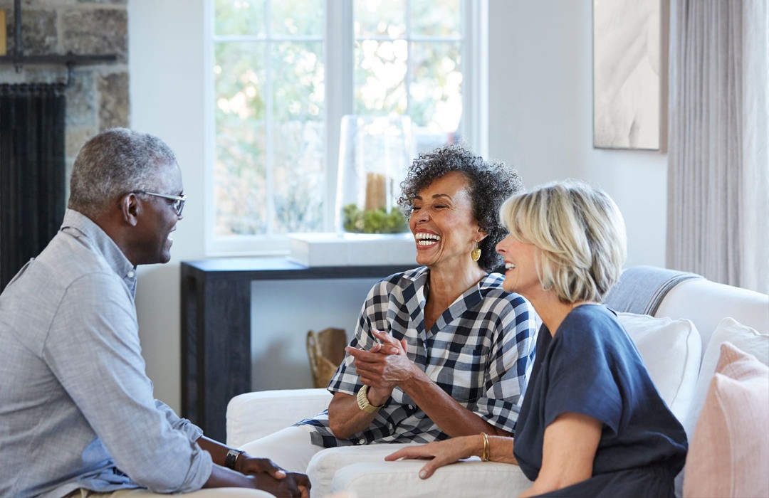 Senior adults talking and sitting in a living room