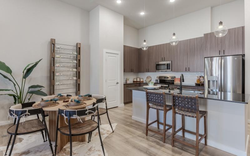 Spacious and well lit kitchen with wood floors and stainless steel appliances