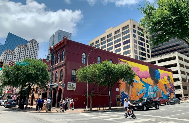 A historical building with a mural painted on the side in downtown Austin.