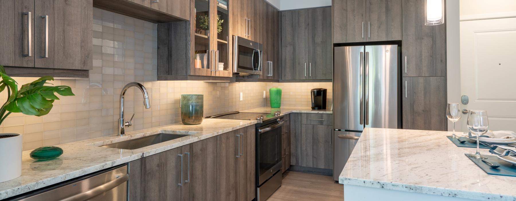 Spacious well lit kitchen with wood floors and stainless steel appliances