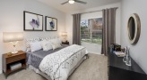 a bedroom with a ceiling fan and light fixture