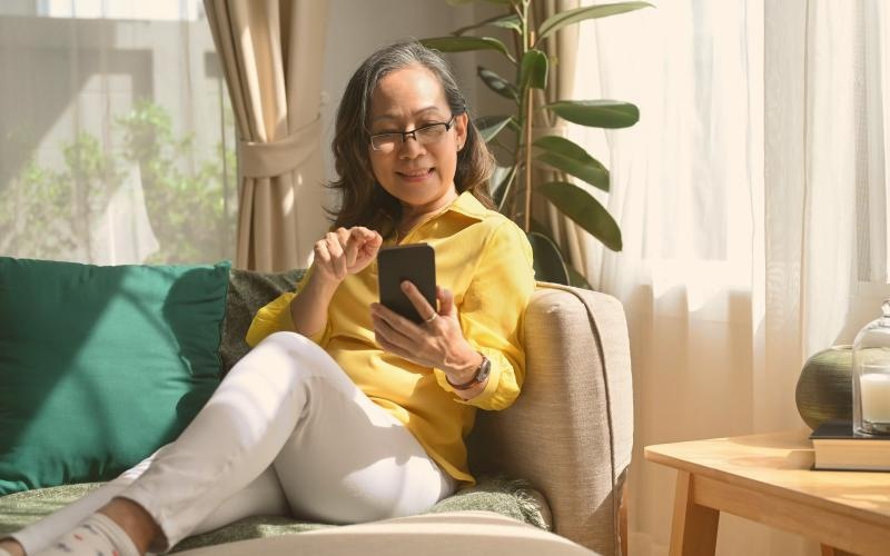 a woman sitting on a couch looking at a phone