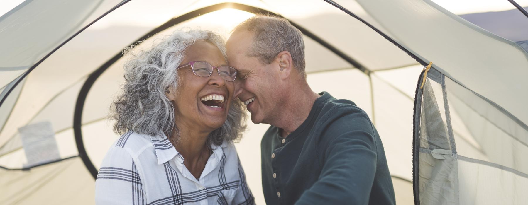 a man and woman laughing in a tent